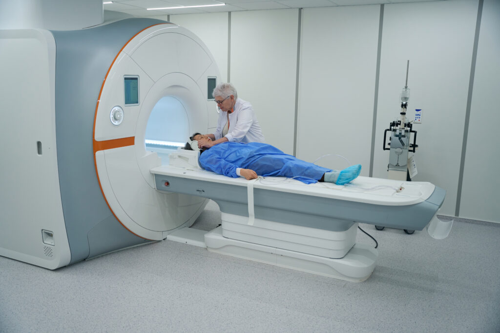 Woman diagnostician prepares a patient for an MRI procedure, the clinic uses modern equipment